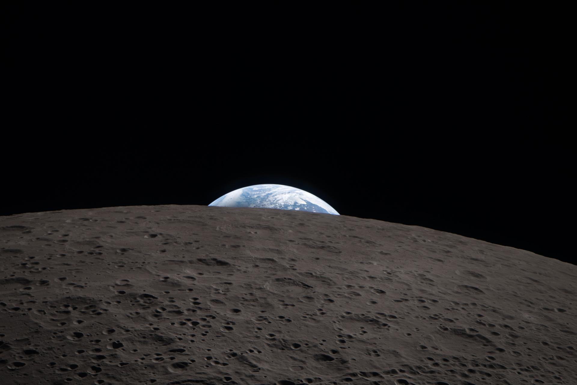 Earth setting behind the curve of the Moon, seen from the Orion spacecraft.